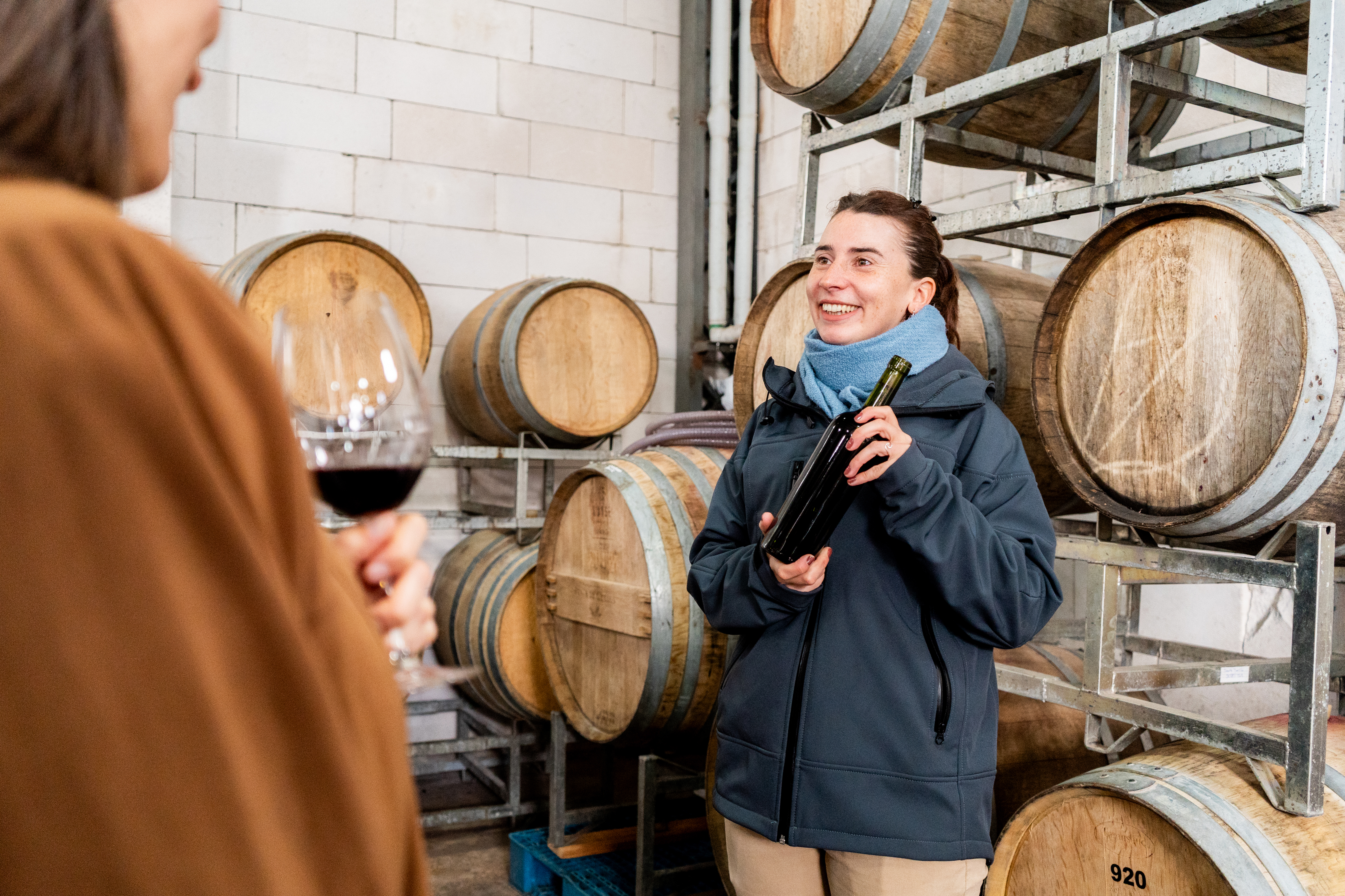 Winery Agritainment A wine maker entertaining guests in a barrel room tasting.